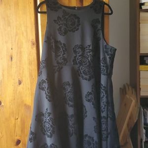 An empire waisted black dress with flower detail.